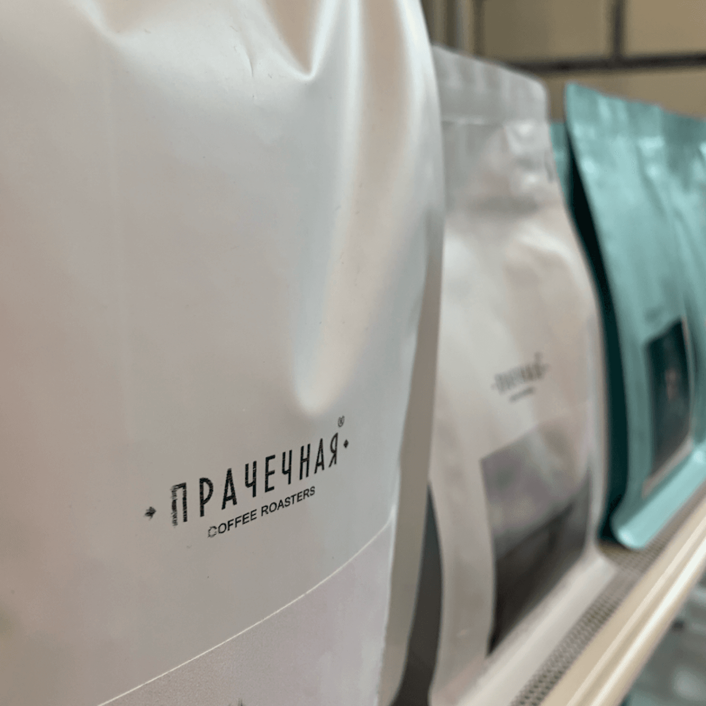 Пачки зерна «Прачечная Coffee Roasters» на полке